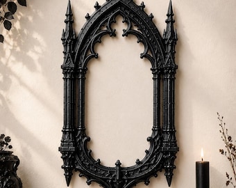Könnte beinhalten: Ein schwarzer Wandspiegel mit einem verzierten Spitzbogenrahmen und komplexen architektonischen Details, die an gotische Kathedralfenster erinnern. Der Rahmen umfasst vertikale Türmchen, Spitzen und dekorative Maßwerkelemente.