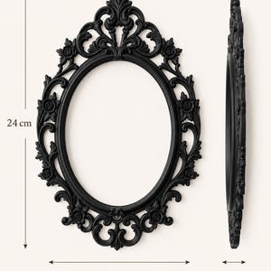 K&ouml;nnte beinhalten: Ein ovaler schwarzer Bilderrahmen mit kunstvollen Blumen- und Schn&ouml;rkelverzierungen. Der Rahmen misst 24 cm in der H&ouml;he, 17 cm in der Breite und 1,5 cm in der Tiefe, wie durch die sichtbaren Messlinien und Beschriftungen im Bild angegeben.