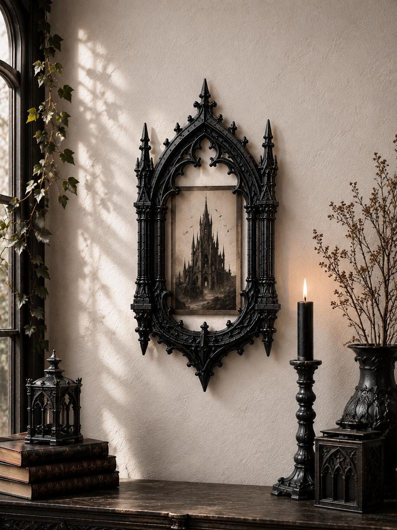 May include: A rectangular wall mirror or frame featuring an intricate black gothic-style border with pointed arches and spires. Inside the frame is a sepia-toned illustration of a tall, dark castle with multiple towers and flying birds.