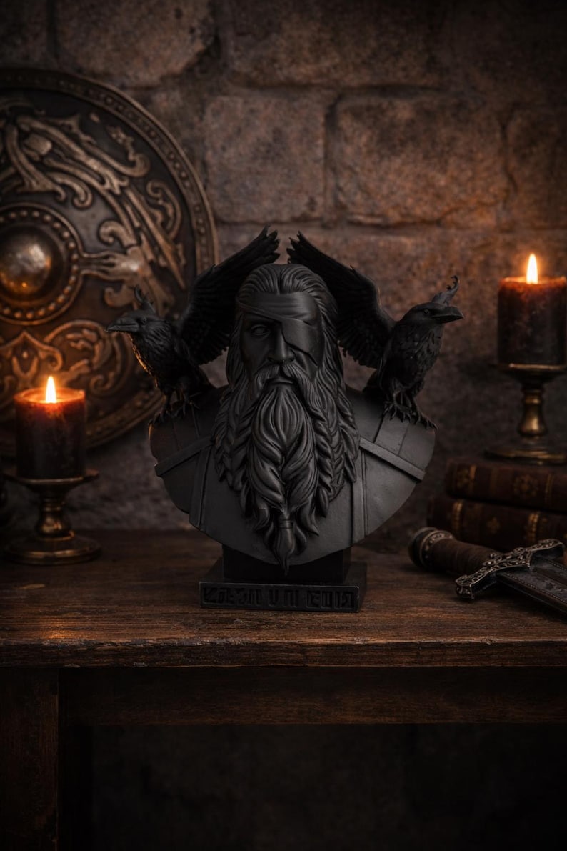 May include: A black bust of a bearded man with a blindfold, flanked by two ravens. The bust is on a wooden surface, with lit candles and a shield in the background. The text "KOSMIUM CULT" is at the base.