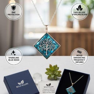 May include: A silver necklace with a square pendant featuring a tree of life design set against a sparkling blue resin background. The necklace is displayed in a navy blue box with the text "BOLD RULERS". The image also includes the text "Jewelry for a Balanced Life."