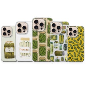 May include: A collection of five phone cases with pickle-themed designs. The cases feature illustrations of pickles in jars, pickle patterns, and the word "Pickles". The cases have a variety of backgrounds, including white and yellow.