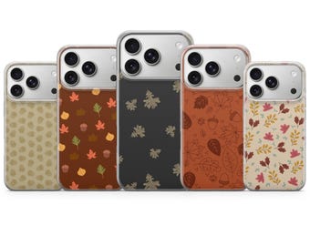 May include: Five smartphone cases arranged in a row, each featuring a distinct autumn-themed pattern. The designs include beige acorns, colorful leaves on brown, oak leaves on dark gray, line-art foliage on orange, and multi-colored leaves on cream.