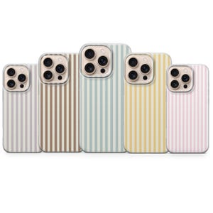 May include: Five phone cases with vertical striped patterns in various pastel colors: lavender, brown, blue, yellow, and pink. Each case has a clear camera lens protector and a matching color scheme.