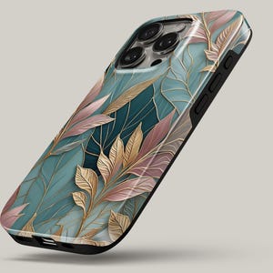 May include: A smartphone case with a botanical design. The case features a teal, pink, and gold leaf pattern with a black border. The design has a glossy finish and a modern aesthetic.
