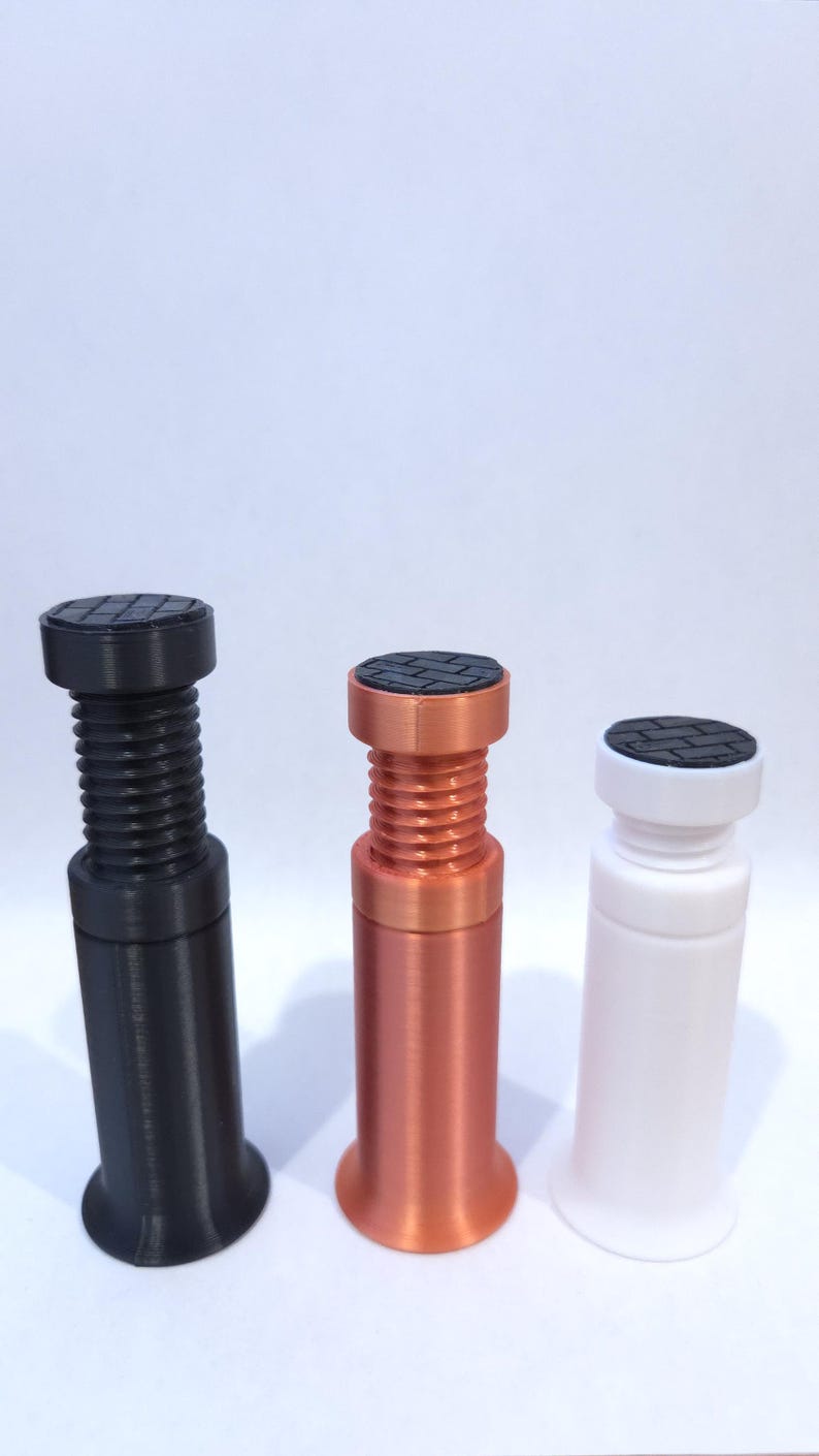 Peut inclure: Trois bouchons d&eacute;coratifs noirs, cuivr&eacute;s et blancs. Chaque bouchon a un dessus circulaire textur&eacute; et un corps filet&eacute;. Les bouchons noirs et cuivr&eacute;s ont une base &eacute;vas&eacute;e, tandis que le blanc a une base cylindrique.