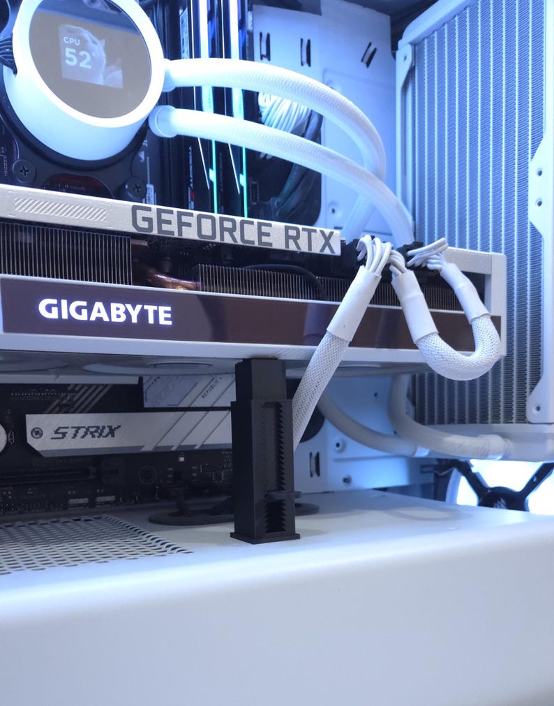 May include: A white computer case interior with a Gigabyte GeForce RTX graphics card. White tubing and a CPU cooler are visible. The text "GIGABYTE" and "GEFORCE RTX" are displayed on the graphics card.