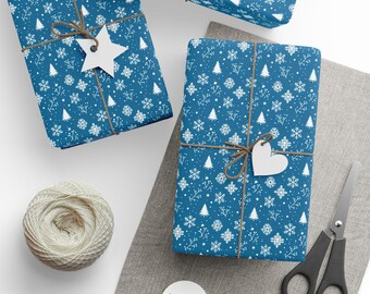May include: Two rectangular gifts wrapped in blue paper with a white pattern of snowflakes, pine trees, and twigs. Each gift is tied with brown twine and features a white paper tag in the shape of a star or heart. A ball of twine and scissors.