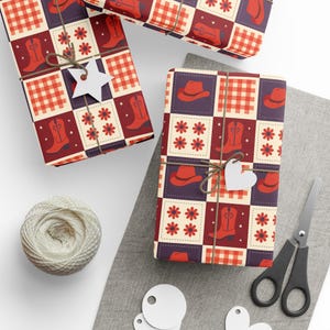 May include: Three wrapped gifts with a Western-themed pattern of cowboy boots, hats, and flowers in red, white, and purple. The gifts are tied with twine and adorned with star and heart-shaped tags. A ball of twine, scissors, and blank tags are also present.