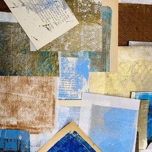 May include: A collage of paper scraps with blue, brown, and gold tones. The paper scraps have different textures and patterns. The text on one of the scraps reads "All the world will see her without regarding the price she paid, the lovely prize in which she doth win, perhaps forever on the melancholy condition of the which compare the human heart."