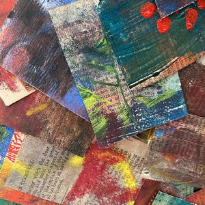 May include: A collection of small, textured art pieces with layered paint and text. The color palette includes reds, blues, greens, and browns. Some pieces feature visible text from what appears to be old book pages.