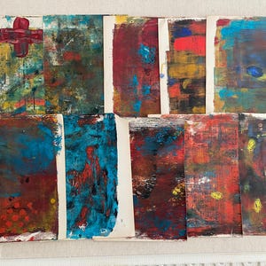 May include: A collection of abstract art pieces, each with unique color palettes and textures. The artworks feature a variety of colors, including red, blue, yellow, and green, with visible brushstrokes and layered paint. A white card with the number 5 is in the upper left corner.