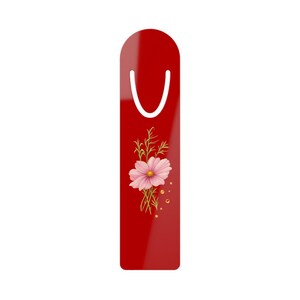 Può includere: Un segnalibro rettangolare rosso con il bordo superiore arrotondato e un intaglio bianco a forma di U vicino alla parte superiore. Il centro del segnalibro mostra un'illustrazione dettagliata di un fiore di cosmea rosa con steli verdi e piccoli punti gialli.