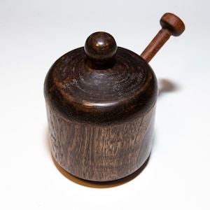Peut inclure: Un récipient en bois brun foncé avec un couvercle et une poignée en bois. Le récipient est en bois avec un motif de grain naturel.