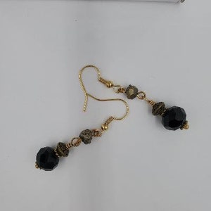Black and Gold!! Black rondell crystal, pyrite nugget charm, metal plated spacer. Gold plated shepherd hook ear wire. HM, NF.