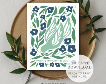 May include: A white card with a green dove design, surrounded by blue flowers and green leaves. The text "WITH SYMPATHY & LOVE" is displayed. The card is on a gold plate with green leaves.