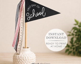 May include: A black triangular pennant flag with the white text First Day of School attached to a wooden dowel. The dowel is decorated with red, white, and black ribbons and sits in a small, textured, off-white ceramic vase. The text Instant Download Ready to Print at Home is visible.