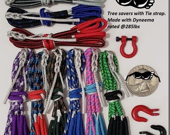 Puede incluir: Una colección de protectores de árboles con correas de amarre, hechos con Dyneema y con una clasificación de 129 kg. La imagen muestra varias combinaciones de colores, incluyendo negro, azul, rojo, morado, verde y rosa. También se incluyen ganchos rojos y negros.
