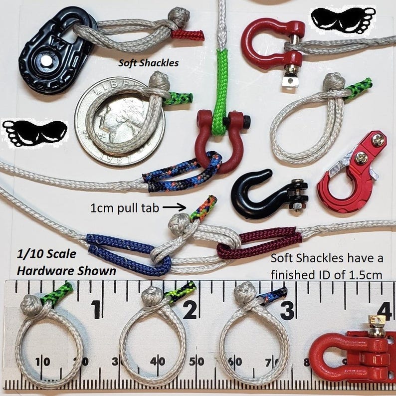 May include: An assortment of soft shackles and hardware components are displayed, including a black pulley, red and black hooks, and various rope knots. The text "Soft Shackles" and "1/10 Scale Hardware Shown" are visible. The finished ID is 1.5cm.