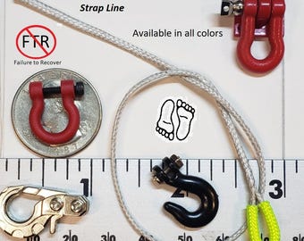 May include: Assortment of miniature red and black metal hooks, a silver rope, and a yellow loop. The image includes the text "Strap Line" and "Failure to Recover". A ruler is in the background.