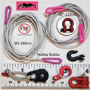 Puede incluir: Un surtido de equipos de recuperaci&oacute;n, que incluye una cuerda gris de 180 cm con detalles en rosa, un grillete rojo y varios ganchos negros y rojos. El texto "FTR Failure to Recover" es visible.