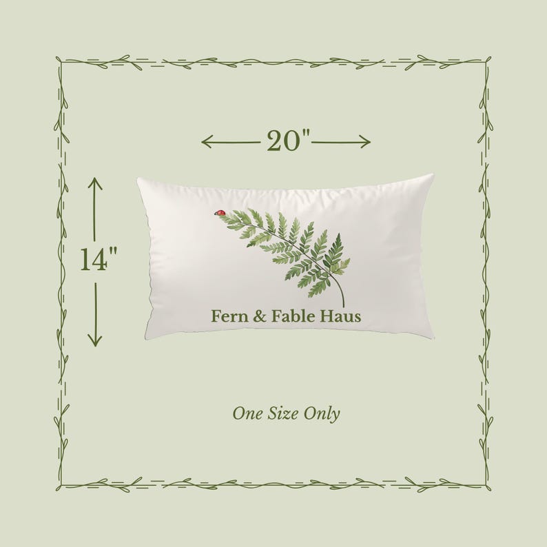 May include: A white rectangular pillow with a fern and ladybug design. The pillow is 20 inches long and 14 inches wide. The text "Fern & Fable Haus" is printed on the pillow. The words "One Size Only" are also printed on the image.