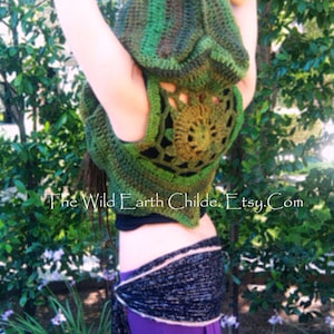 May include: A green and brown crocheted hooded vest with a lacy back design. The vest is worn over a black top and a purple skirt with a black and white patterned belt.
