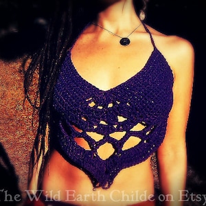 May include: Purple crochet halter top with a geometric design. The top has a low neckline and is made with a delicate, open-weave pattern.