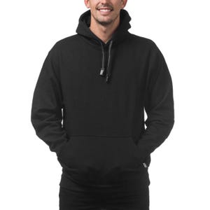 May include: A black hooded sweatshirt with a front kangaroo pocket and drawstring hood. The sweatshirt is made of a soft material and is suitable for casual wear. The image shows the sweatshirt on a person.