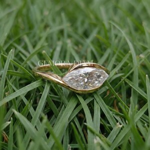 Symmetrical marquise cut facets close up, VVS clarity moissanite in 10k gold bezel, precision craftsmanship.