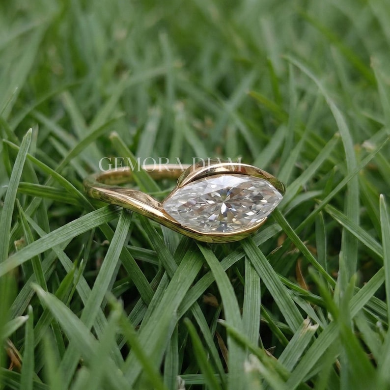 Symmetrical marquise cut facets close up, VVS clarity moissanite in 10k gold bezel, precision craftsmanship.