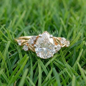 Pear cut lab grown diamond engagement ring in 14k solid gold featuring a unique botanical leaf cluster setting with marquise accents.