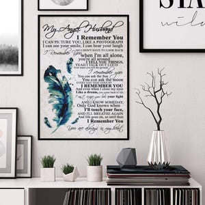 May include: A framed print with the text "My Angel Husband" and a poem about remembrance. The artwork features a blue and teal feather design. The print is displayed on a white shelf with other decorative items.