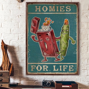 May include: A framed vintage-style poster with the text "HOMIES FOR LIFE." The artwork features a cartoon lighter with flames and a cartoon marijuana cigarette, both with arms and legs, against a teal background.