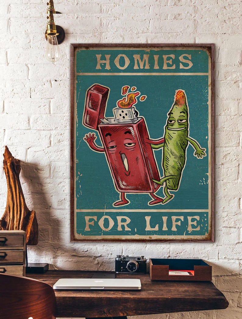 May include: A framed vintage-style poster with the text "HOMIES FOR LIFE." The artwork features a cartoon lighter with flames and a cartoon marijuana cigarette, both with arms and legs, against a teal background.