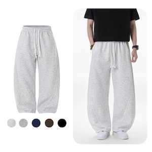 May include: Light gray sweatpants with a drawstring waist and a relaxed fit. The pants are shown in a studio setting and on a person. The image also shows a color palette of gray, dark gray, navy, brown, and black.