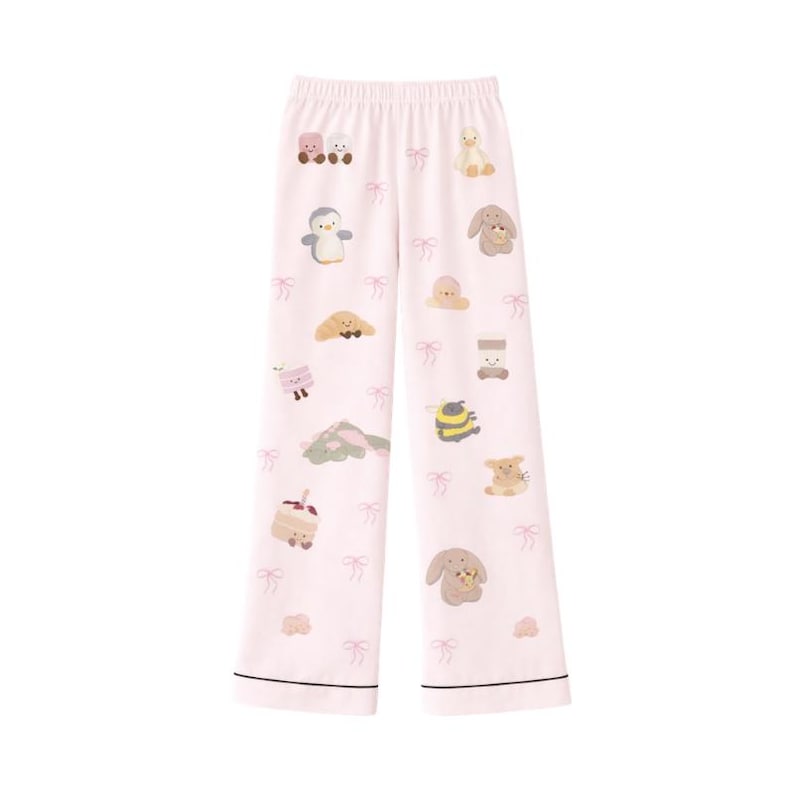 Puede incluir: Pantalones de pijama de color rosa claro con un estampado repetido de animales de dibujos animados y lazos rosas. Los pantalones tienen un ribete negro en el dobladillo y la cintura. Los animales de dibujos animados incluyen un ping&uuml;ino, un conejito, un oso y otros personajes lindos.