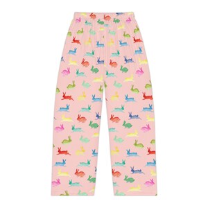 Puede incluir: Pantalones de pijama rosas con un estampado repetido de conejitos de acuarela coloridos. Los conejitos son en tonos de rojo, amarillo, verde, azul y rosa. Los pantalones tienen un corte holgado y un dise&ntilde;o c&oacute;modo.