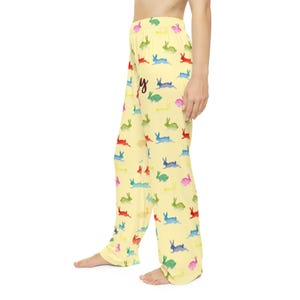 Puede incluir: Pantalones de pijama amarillo claro con un estampado repetido de conejitos de acuarela coloridos. La palabra "Happy" est&aacute; escrita en cursiva en los pantalones. Los pantalones est&aacute;n hechos de una tela suave y fluida.