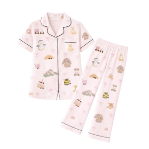Puede incluir: Un conjunto de pijama rosa claro con una camisa de manga corta con botones y pantalones a juego. El conjunto est&aacute; decorado con dibujos de animales de dibujos animados, comida y lazos. Los bordes del conjunto est&aacute;n ribeteados con ribetes negros.
