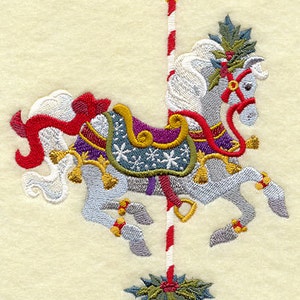 Puede incluir: Un caballo de carrusel blanco con una silla roja, dorada y morada, decorada con copos de nieve. El caballo tiene un poste a rayas rojo y blanco y una rama de acebo verde en la base.