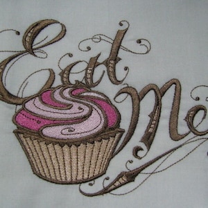 May include: Embroidered design of a cupcake with pink and white frosting and the words "Eat Me" in brown cursive script.