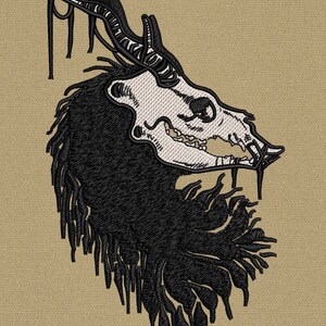 May include: Black and white embroidered design of a skull with horns and a long mane of hair. The skull is detailed with teeth and eye sockets. The design is on a beige background.