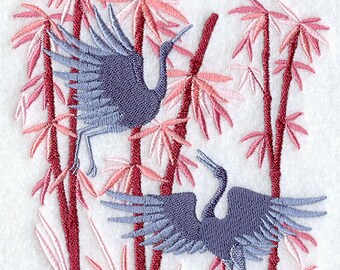 May include: Two blue cranes with outstretched wings stand in a grove of pink bamboo trees. The cranes are stylised and embroidered with a detailed design.