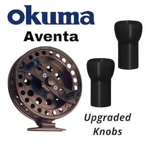 Puede incluir: Un carrete de pesca Okuma Aventa de color bronce con un diseño circular y múltiples agujeros. La imagen también muestra dos perillas negras mejoradas. El logotipo de Okuma y la palabra "Aventa" se muestran en azul y negro.