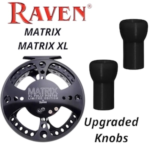 Puede incluir: Carrete de pesca Raven Matrix XL negro de edición limitada totalmente perforado con perillas negras mejoradas. El carrete tiene un diseño circular con múltiples agujeros y el texto "Raven" y "Matrix" en rojo y negro.