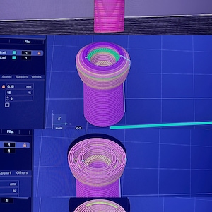 K&ouml;nnte beinhalten: Ein 3D-Rendering eines zylindrischen Objekts mit ausgestellter Oberseite, dargestellt in mehreren Ansichten. Das Objekt ist haupts&auml;chlich magenta, mit B&auml;ndern in Gelb, Gr&uuml;n und anderen Farben. Die Bilder werden auf blauem Rasterhintergrund angezeigt.