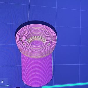 K&ouml;nnte beinhalten: Ein 3D-gerendertes Modell eines zylindrischen Objekts mit einem komplexen, geschichteten Design. Das Objekt ist haupts&auml;chlich rosa mit gelben und beigen Akzenten und vor einem blauen Rasterhintergrund platziert. Es ist ein digitales Rendering.
