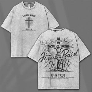 May include: Gray t-shirt with a graphic design featuring a cross and the text "KING OF KINGS" and "JOHN 19:30" on the front. The back of the shirt displays an image of Jesus on the cross with the text "Jesus Paid It All" and "JOHN 19:30".