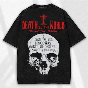 May include: Black oversized t-shirt with a distressed look. The back features red text that reads "DEATH TO THE WORLD" and "The Last True Rebellion." Below the text is a white skull graphic with the words "WHAT YOU ARE ONCE WAS WHAT I AM YOU WILL SURELY BECOME."
